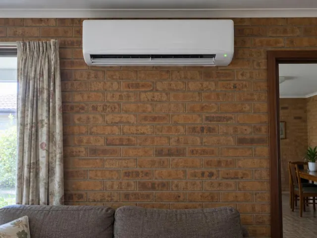 Clean split system mounted high on a brick living room wall with louvre open in Hope Valley